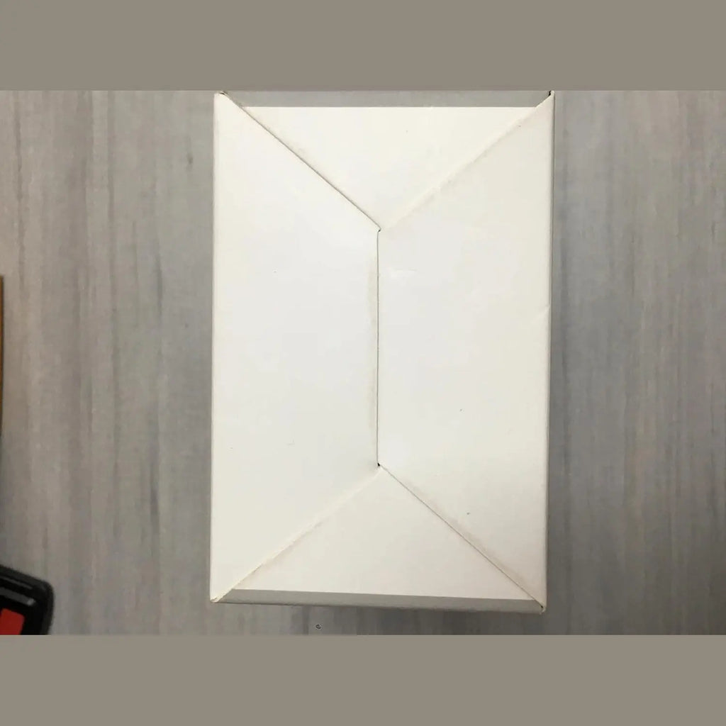 Folded white shipping box for black action camera with red accessory detail