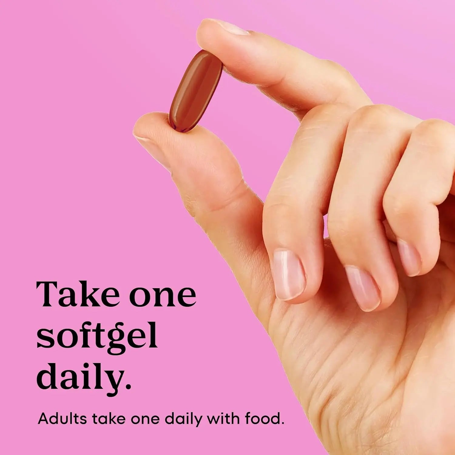Brown oval softgel prenatal vitamin held in hand showing daily dosage size