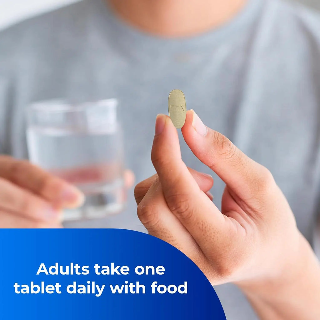 Man holding yellow One A Day pre-conception health tablet with water