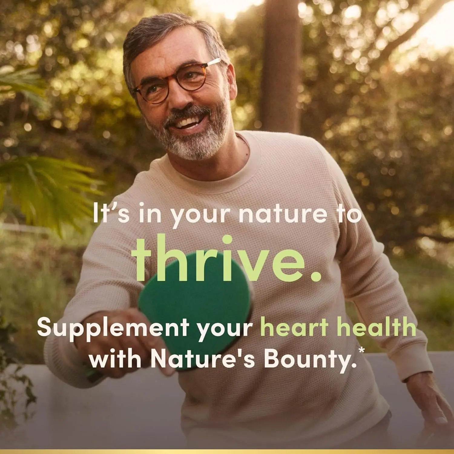 Man holding Nature's Bounty Co Q-10 supplement for heart health outdoors